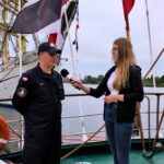 zdjęcie przedstawiające młodego marynarza, który udziela wywiadu dziennikarce na staku