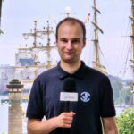 zdjęcie przedstawiające mężczyznę wypowiadającą się młodego mężczyznę do mikrofonu