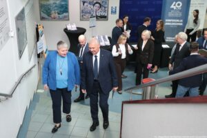 Ujęcie z góry. Uczestnicy wchodzący po schodach na uroczystość 40-lecia Instytutu Nauk o Polityce i Bezpieczeństwie Uniwersytetu Szczecińskiego. Na pierwszym planie rektor uczelni i prorektorka ds. organizacji. W tle pozostali uczestnicy.