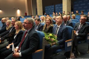 Uroczystość 40-lecia Instytutu Nauk o Polityce i Bezpieczeństwie Uniwersytetu Szczecińskiego. Aula. Ujęcie bokiem na uczestników wydarzenia.