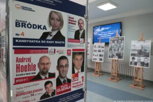 40-lecie Instytutu Nauk o Polityce i Bezpieczeństwie Uniwersytetu Szczecińskiego. Korytarz. Po lewej fragment wystawy plansz z plakatami i ulotkami wyborczymi absolwentów uczelni. W tle wystawa nawiązująca do historii Instytutu.