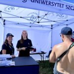 zdjęcie stoiska US, na zdjęciu dwie kobiety pod namiotem oraz mężczyzna odwrócony plecami