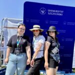 zdjęcie 3 kobiet na ściance US na świeżym powietrzu