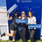 zdjęcie 3 kobiet na ściance US na świeżym powietrzu