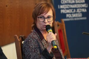 Prelegentka III Międzynarodowego Kongresu Języka i Kultury Polskiej trzymająca mikrofon. Ujęcie do piersi (bokiem).