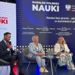 Dwie ekspertki po prawej stronie i prowadzący rozmowę po lewej stronie siedzą na szarych fotelach podczas dyskusji panelowej. W tle granatowy ekran z białym napisem: Pawilon Polskiej Nauki i logo Ministerstwa Nauki i Szkolnictwa Wyższego z orłem w koronie. Poniżej tytuł dyskusji: „Nauka bez granic – jak mówić o nauce w kontekście globalnym?” i wymienieni uczestnicy rozmowy.