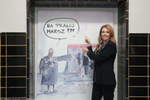 Otwarcie budynku Wydziału Prawa i Administracji Uniwersytetu Szczecińskiego. Duża grafika z sędzią i napisem: Na prawo marsz! Obok grafiki dziekan Wydziału dr hab. Ewelina Cała-Wacinkiewicz, prof. US wskazująca palcami na obraz.