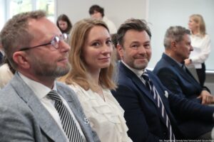 Otwarcie budynku Wydziału Prawa i Administracji Uniwersytetu Szczecińskiego. Ujęcie bokiem na ludzi siedzących w rzędach w sali – w tym na prodziekanów Wydziału.