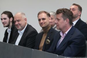 Otwarcie budynku Wydziału Prawa i Administracji Uniwersytetu Szczecińskiego. Ujęcie bokiem na ludzi siedzących w rzędach w sali.