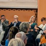 zdjęcie przedstawiające grającego na gitarze mężczyznę się mężczyznę, oraz część wsłuchanej publiczności