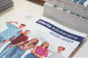 Leżący bokiem informator Uniwersytetu Szczecińskiego z ofertą edukacyjną na 2026–2027 rok. Na okładce na białym tle grupa uśmiechniętych studentów w kolorowych koszulkach.