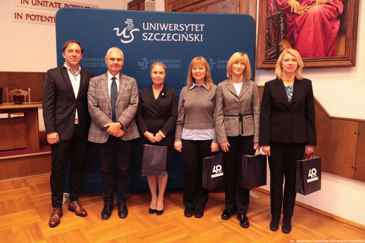 zdjęcie przedstawiające grupę ludzi pozujących na ściance US