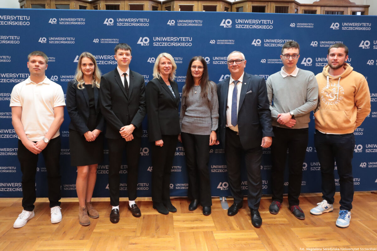 zdjęcie przedstawiające grupę ludzi pozujących na ściance US