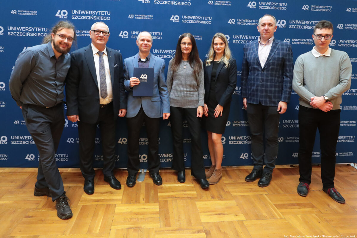 zdjęcie przedstawiające grupę ludzi pozujących na ściance US