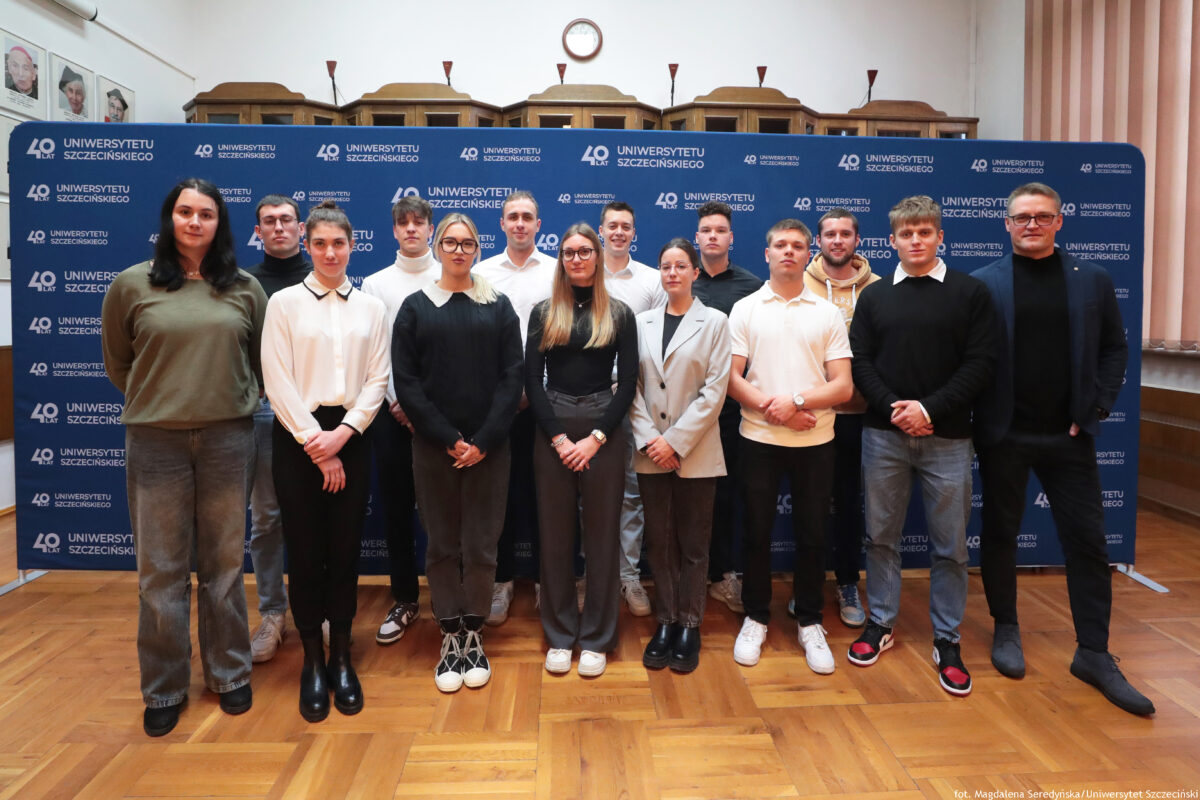 zdjęcie przedstawiające grupę ludzi pozujących na ściance US