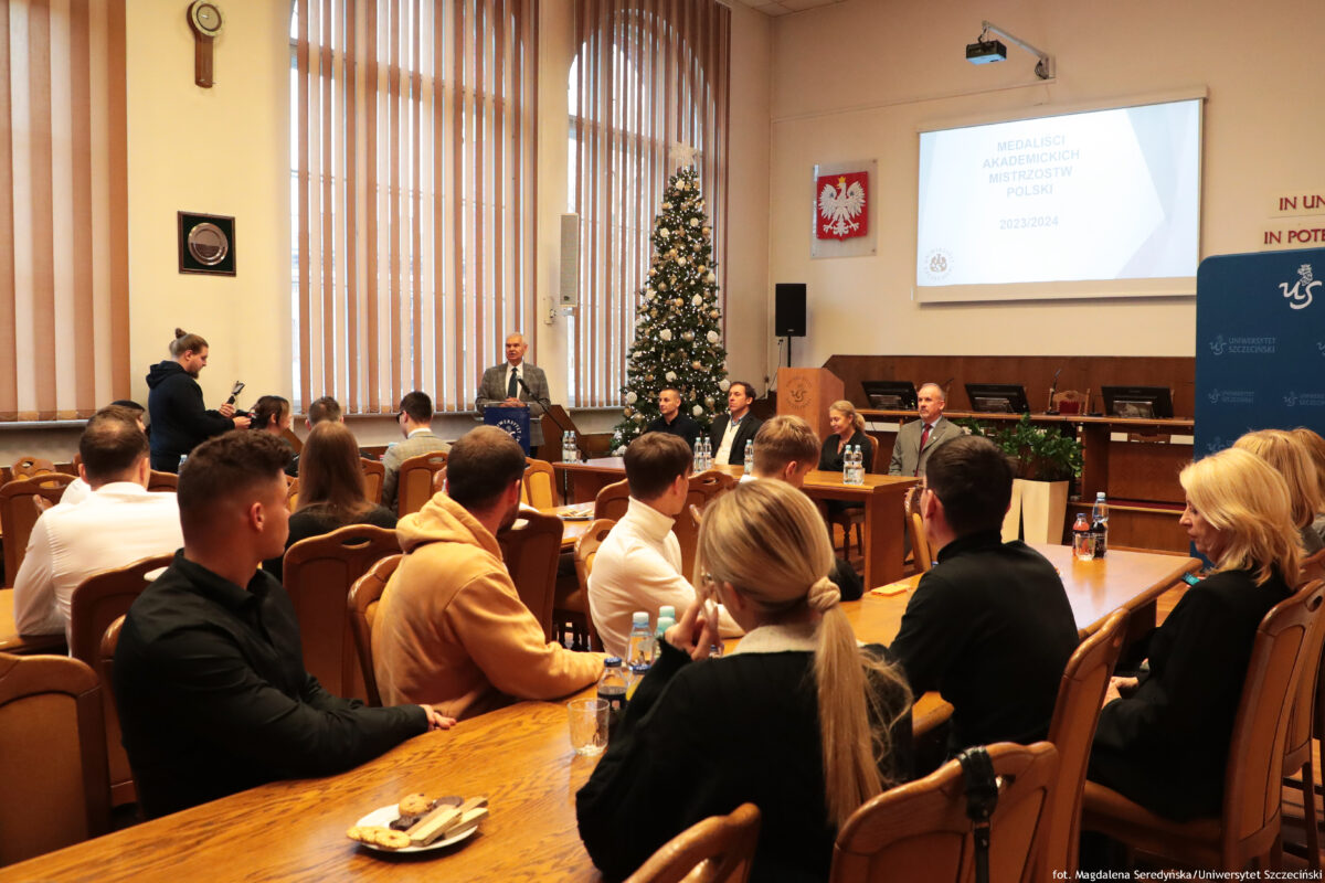 zdjęcie grupy ludzi siędzących w sali senatu podczas spotkania, jeden z mężczyzn stojący przy mównicy