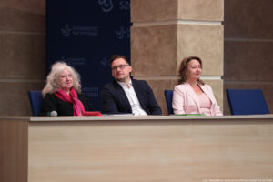 Aula. Stół, za którym siedzi troje przedstawicieli uczelni. Po lewej dziekan Wydziału Nauk Społecznych – dr hab. Irena Ramik-Mażewska, profesor US.