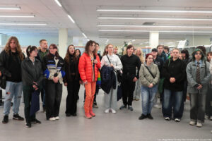 Około 30-osobowa grupa studentów w Muzeum Geologiczny Uniwersytetu Szczecińskiego. W tle wysokie przeszklone gabloty z eksponatami.