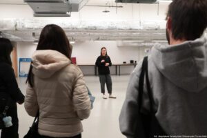 Rescue LAB – miejsce, w którym każdy może nauczyć się udzielania pierwszej pomocy. Na środku prowadząca. Na pierwszym planie tyłem troje studentów.