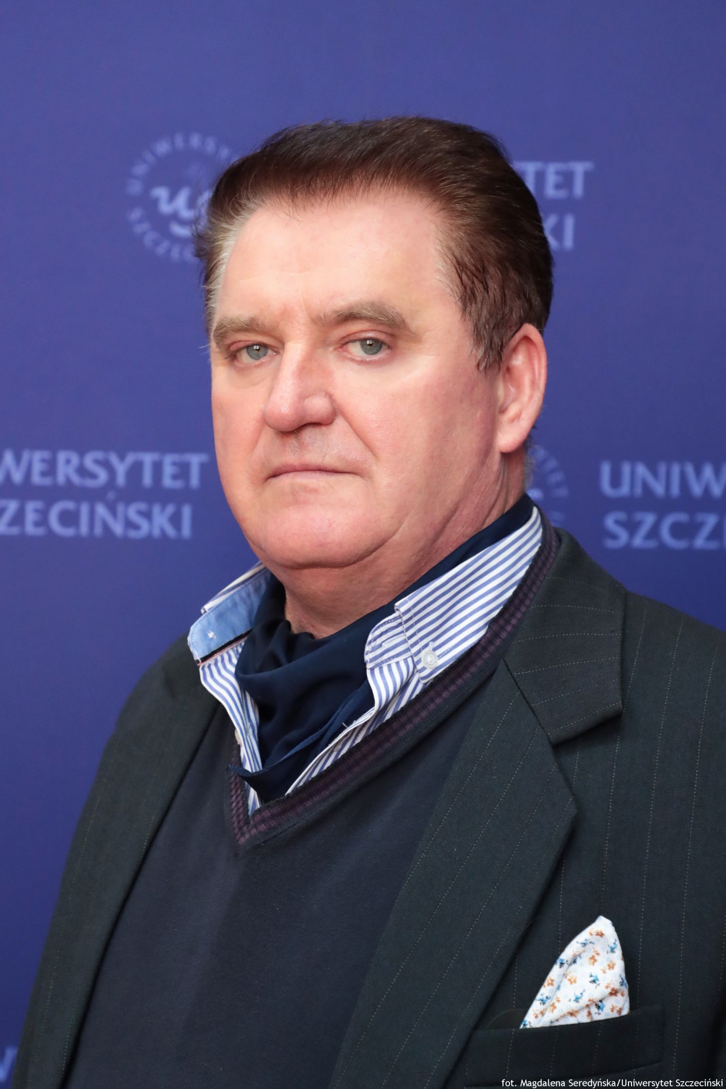 Portret mężczyzny na tle granatowej ścianki US