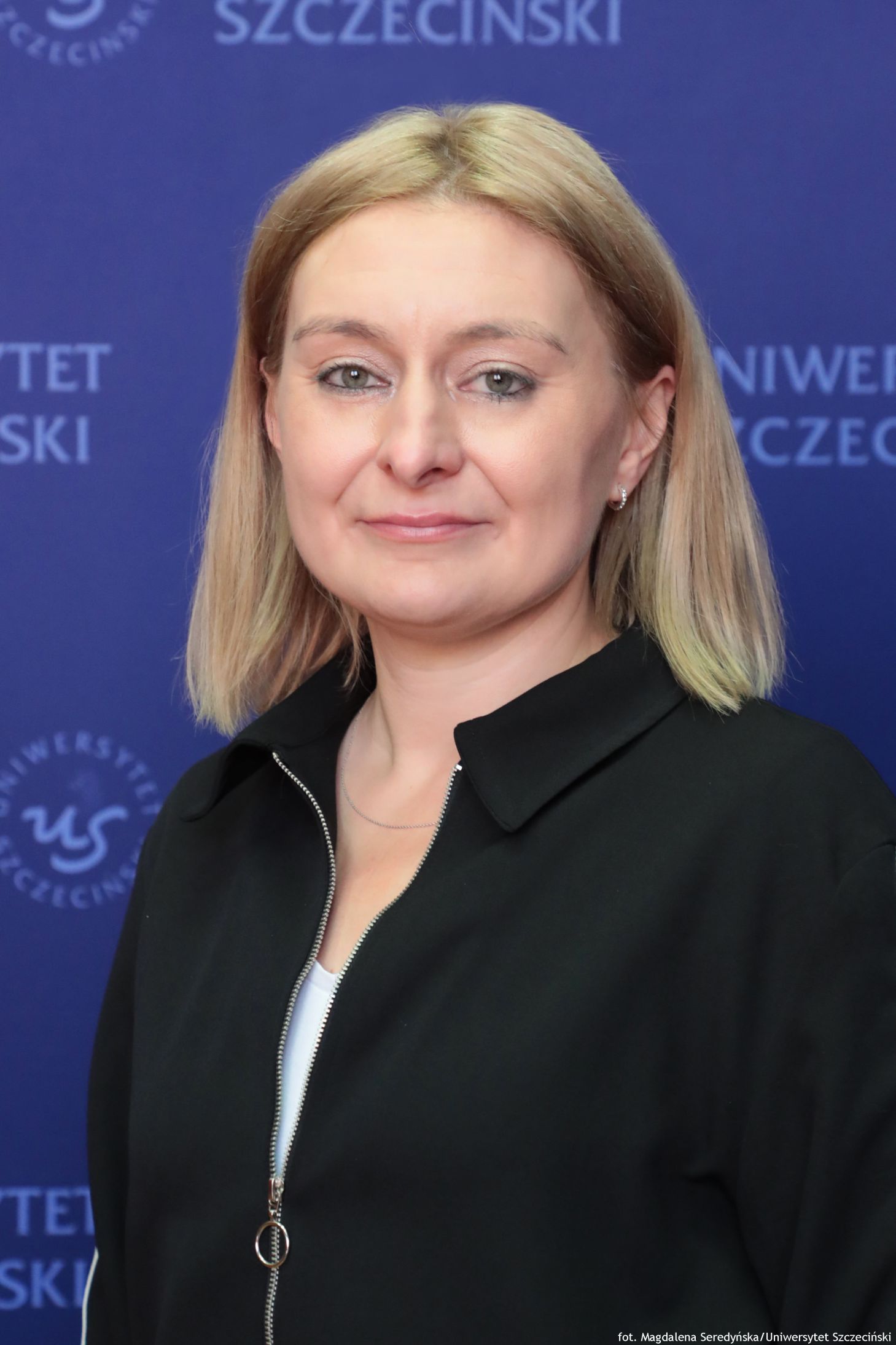 Portret kobiety na tle granatowej ścianki US.