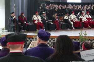 Inauguracja roku akademickiego. Scena. Na niej rektorzy szczecińskich uczelni w czerwonych togach z gronostajami. W tle chór ubrany na czarno. Z przodu widownia (tyłem).