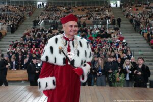 Inauguracja roku akademickiego. Scena. Rektor Uniwersytetu Szczecińskiego z berłem, ubrany w czerwoną togę z gronostajami. W tle widownia Teatru Letniego.