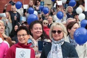 Spacerek na uniwerek. Przed zabytkowym gmachem rektoratu Uniwersytetu Szczecińskiego stoją ludzie z białymi i granatowymi balonikami.
