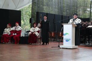 Inauguracja roku akademickiego. Po prawej za białą mównicą rektor Zachodniopomorskiego Uniwersytetu Technologicznego ubrany w czarną togę z gronostajami. Za nim w tle instrumenty i ubrany na czarno chór. Po lewej troje rektorów szczecińskich uczelni w czerwonych togach z gronostajami. Obok nich stoi pedel w czarnej todze.