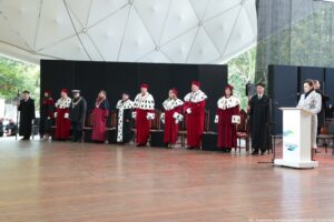 Inauguracja roku akademickiego. Scena. Na niej rektorzy szczecińskich uczelni w czerwonych togach z gronostajami. Po prawej rzeczniczka prasowa za białą mównicą.