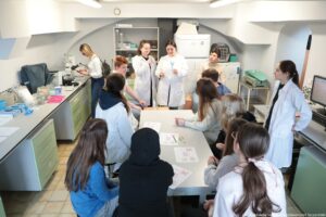 Noc Biologów 2026. Laboratorium. Nastoletni uczniowie w białych fartuchach przygotowują się do przeprowadzenia eksperymentu.