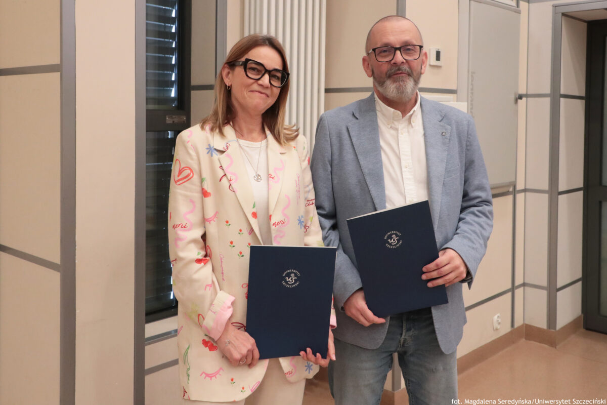 Perły Instytutu Ekonomii i Finansów 2025. Dwoje wyróżnionych naukowców pozuje do zdjęcia z teczkami.