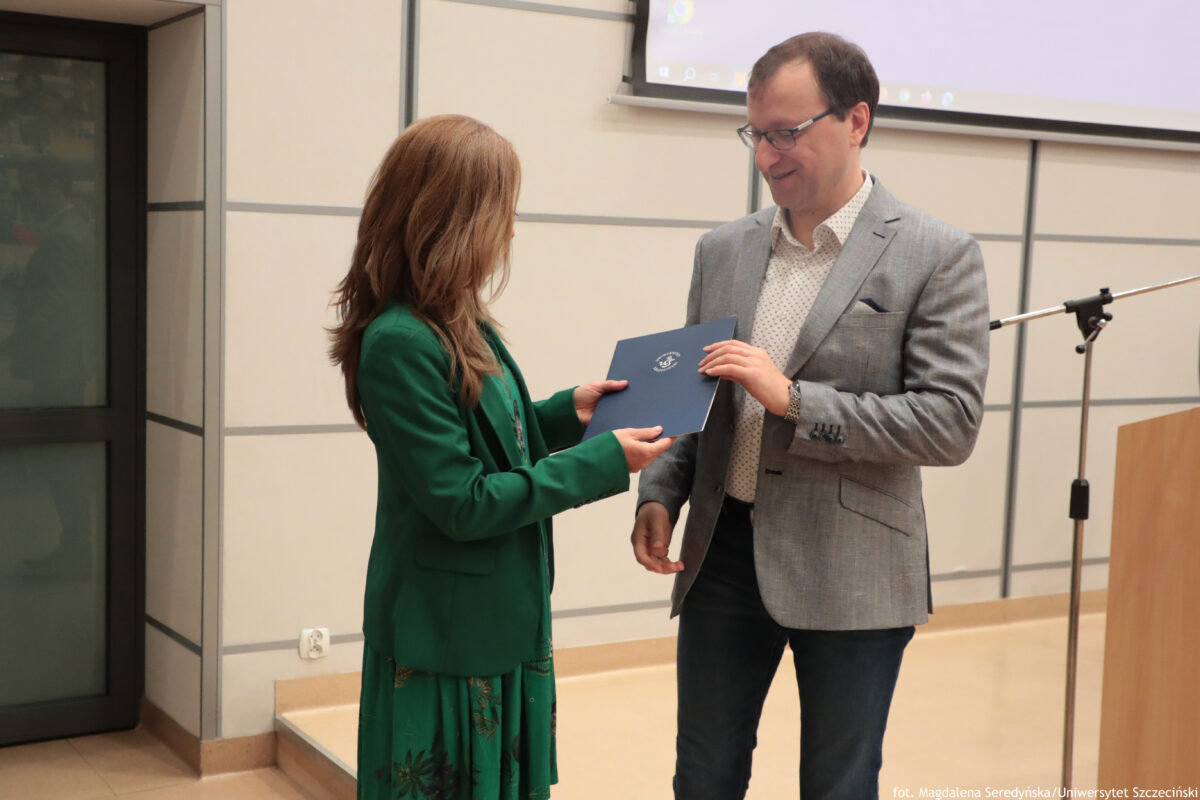 Perły Instytutu Ekonomii i Finansów 2025. Po prawej wyróżniony naukowiec odbiera teczkę od dyrektorki Instytutu.