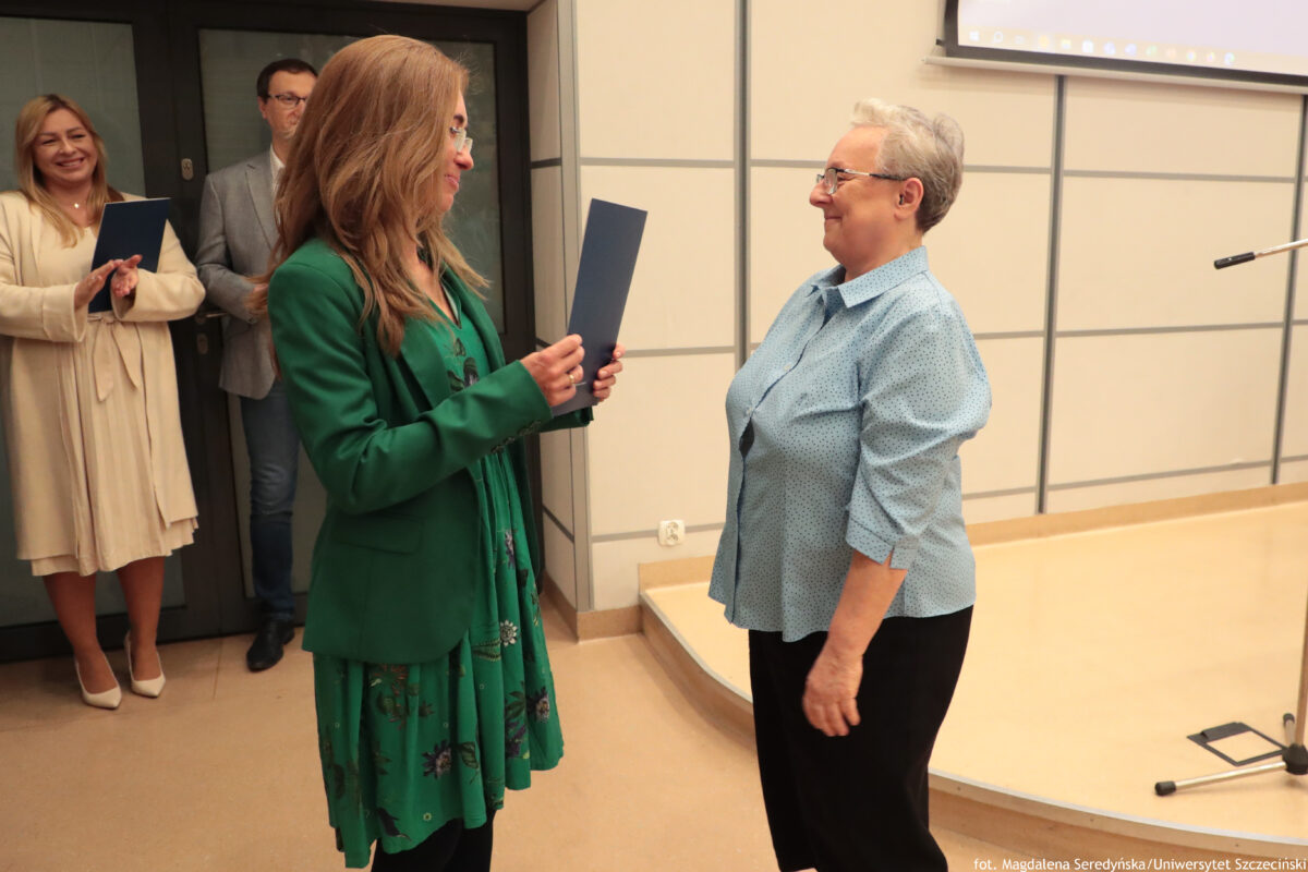 Perły Instytutu Ekonomii i Finansów 2025. Po prawej wyróżniona pracownica jednostki odbiera teczkę do dyrektorki Instytutu.