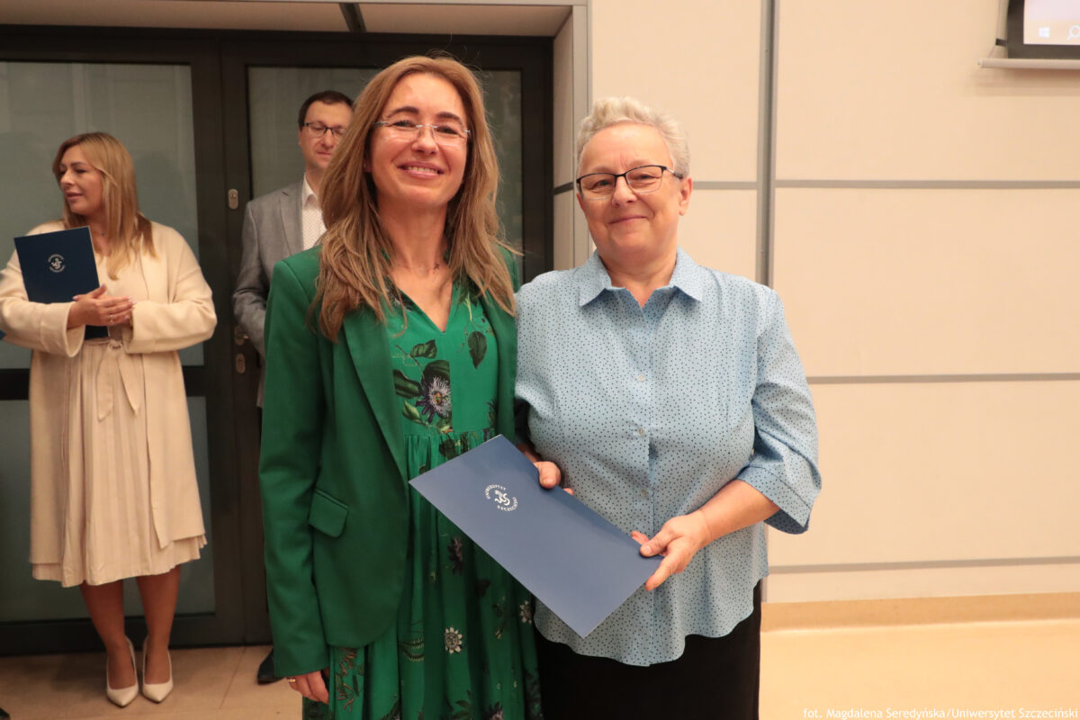 Perły Instytutu Ekonomii i Finansów 2025. Po prawej wyróżniona pracownica jednostki pozuje do zdjęcia z dyrektorką Instytutu. W tle po lewej dwoje innych wyróżnionych.