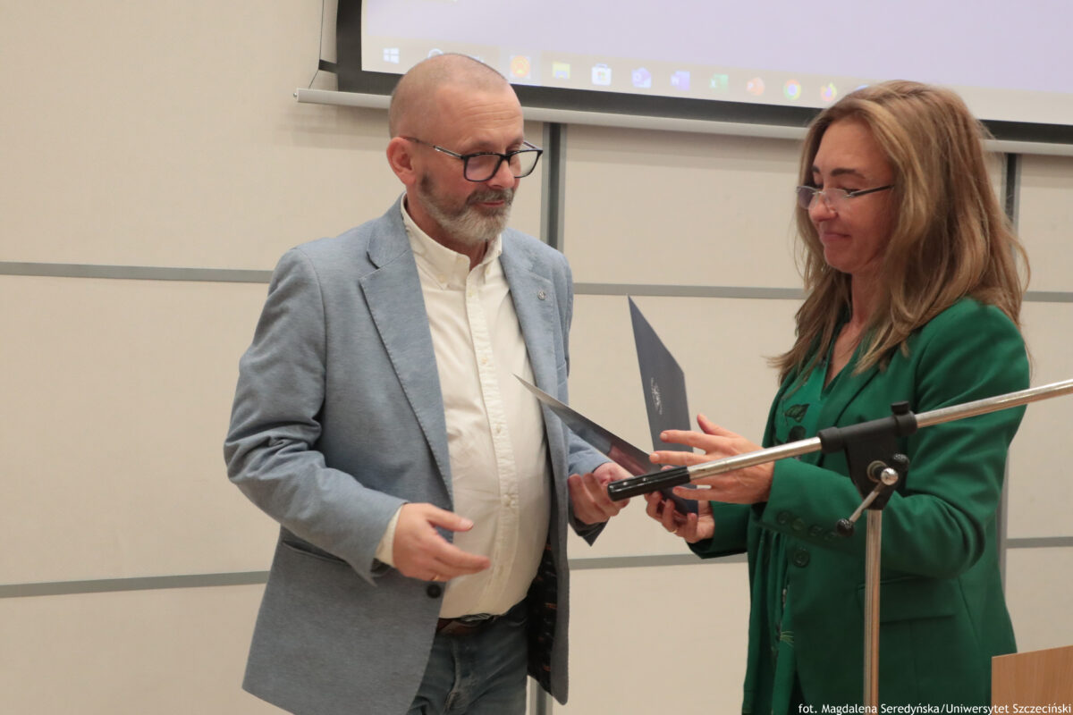 Perły Instytutu Ekonomii i Finansów 2025. Po lewej wyróżniony naukowiec odbiera teczkę od dyrektorki Instytutu.